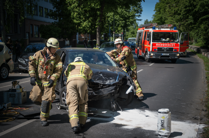 Berlin: Feuerwehrmänner schieben ein Unfallauto von der Straße. Personalmangel und fehlender Nachwuchs bestimmen den Feuerwehralltag.